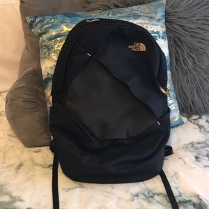 Black and gold north face backpack